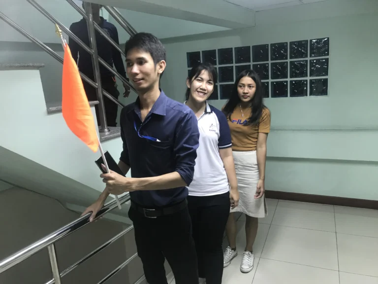 ขบวนพนักงานเคลื่อนที่ผ่านเส้นทางหนีไฟที่มีป้ายบอกทางชัดเจนในระหว่างการฝึกซ้อม Fire Drill โดย TFGC